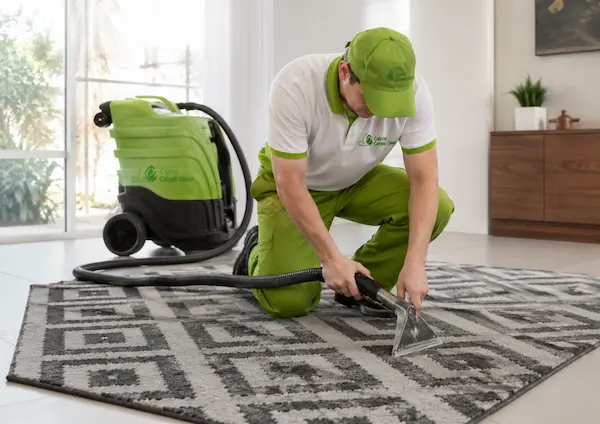 Cairns Carpet Clean technician performing rug cleaning on a grey patterned rug using steam extraction equipment